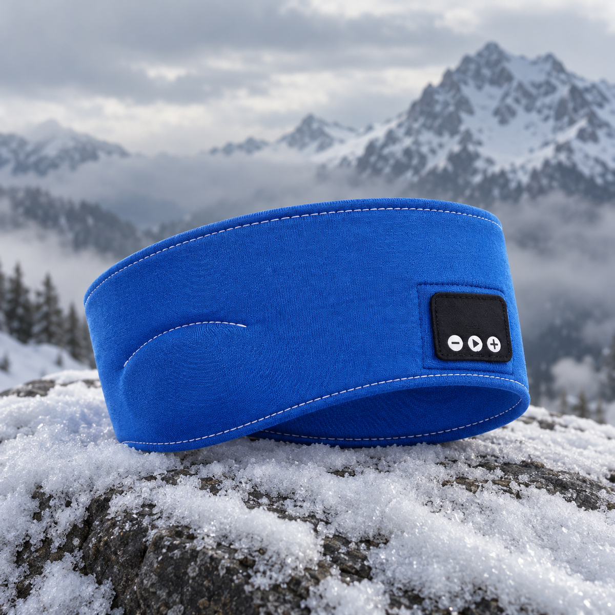 Blått Bluetooth-pannband på en snötäckt sten i fjällen