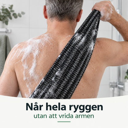 Man skrubbar övre ryggen med den långa skrubbhandduken i duschen