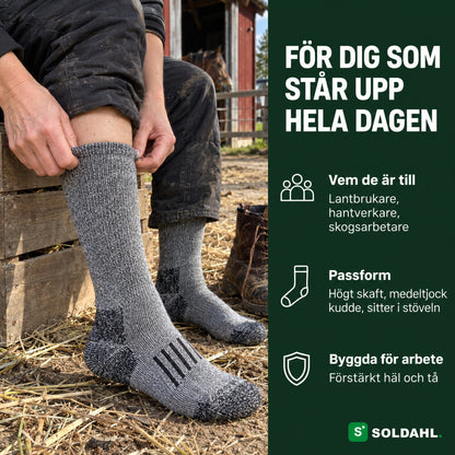 Kvinna drar på sig grå arbetsstrumpa i en stallgård, för dig som står upp hela dagen