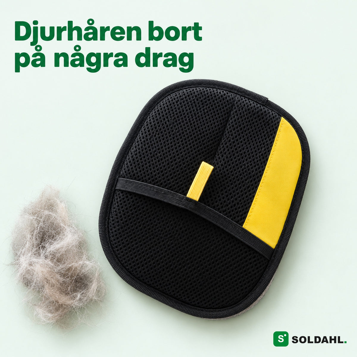 Soldahl husdjurshårvante med svart nätficka och gul flik bredvid en tuss katthår