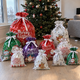Ett pack Snabbklapp: 10 julklappspåsar med dragsko och vit rosett under granen