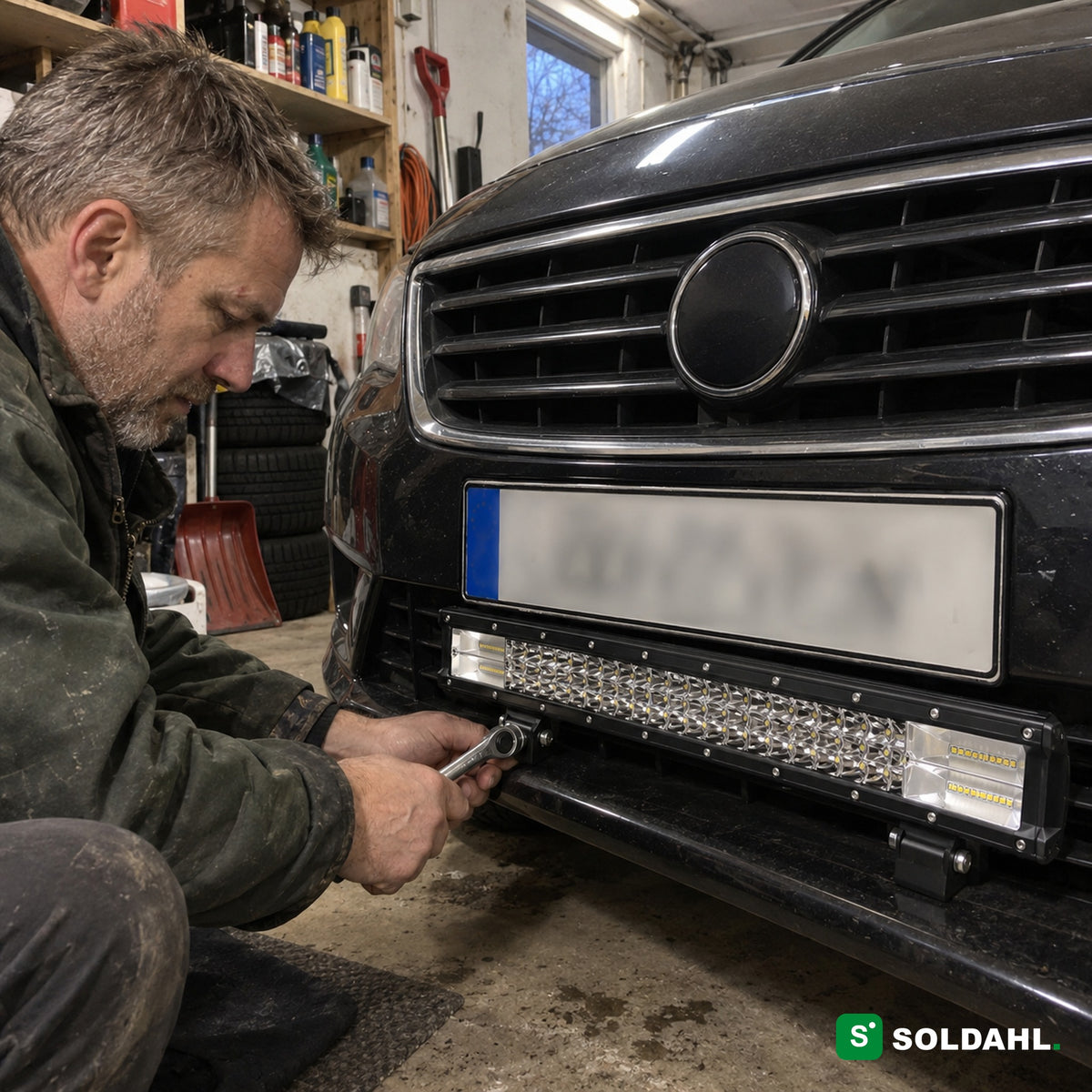 Man monterar LED-ramp under skylten på en bil i ett garage