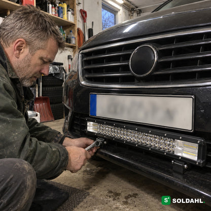 Man monterar LED-ramp under skylten på en bil i ett garage